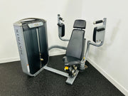 A black and gray Matrix G7 Commercial Pec Fly Machine with padded supports and adjustable seat, positioned on a floor with a white wall in the background.